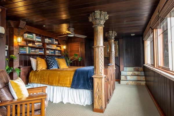 Hacienda Suite with ornate columns, golden bedding and dark wood paneling
