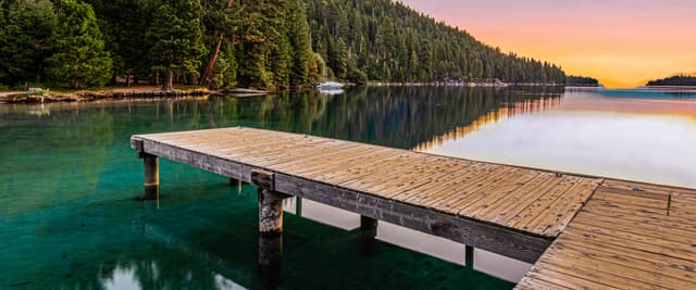 Wooden dock at sunset on a pine-lined lake, Lake Tahoe